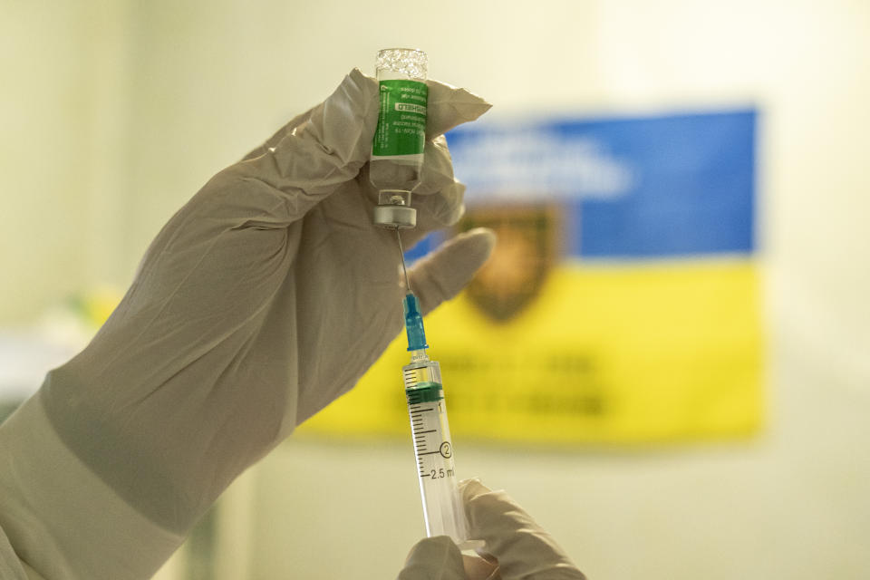 A medic prepares to administer a dose of an AstraZeneca COVID-19 vaccine marketed under the name CoviShield, to a Ukrainian serviceman at a military base near the front-line town of Krasnohorivka, eastern Ukraine, Friday, March 5, 2021. Ukrainians are becoming increasingly opposed to vaccination: an opinion poll this month by the Kyiv International Institute of Sociology found 60% of the country's people don't want to get vaccinated, up from 40% a month earlier. (AP Photo/Evgeniy Maloletka)