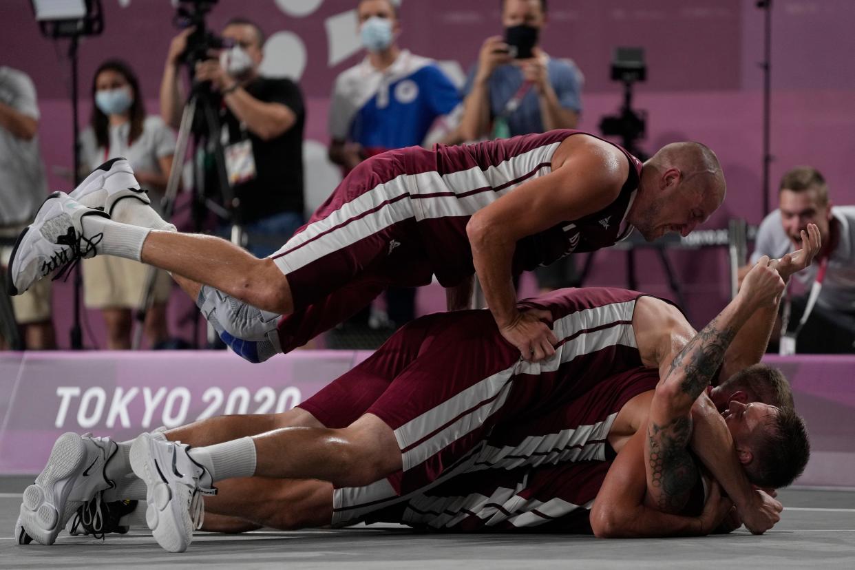 Members of team Latvia celebrate after defeating the Russian Olympic Committee to win the men's 3-on-3 basketball gold medal at the 2020 Summer Olympics, Wednesday, July 28, 2021, in Tokyo, Japan.