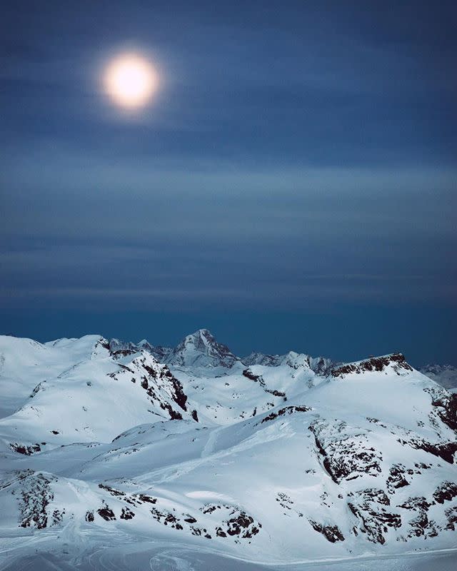 <p>And she shoots during the day <em>and </em>night. Here, a full moon over a mountain range looks almost painted onto the sky.</p>