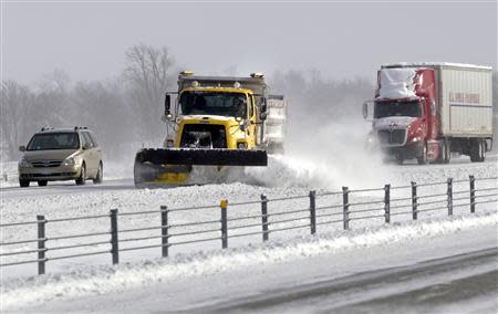 A snow plow clears the road on Interstate 65 north of Indianapolis, Indiana January 6, 2014. REUTERS/Nate Chute