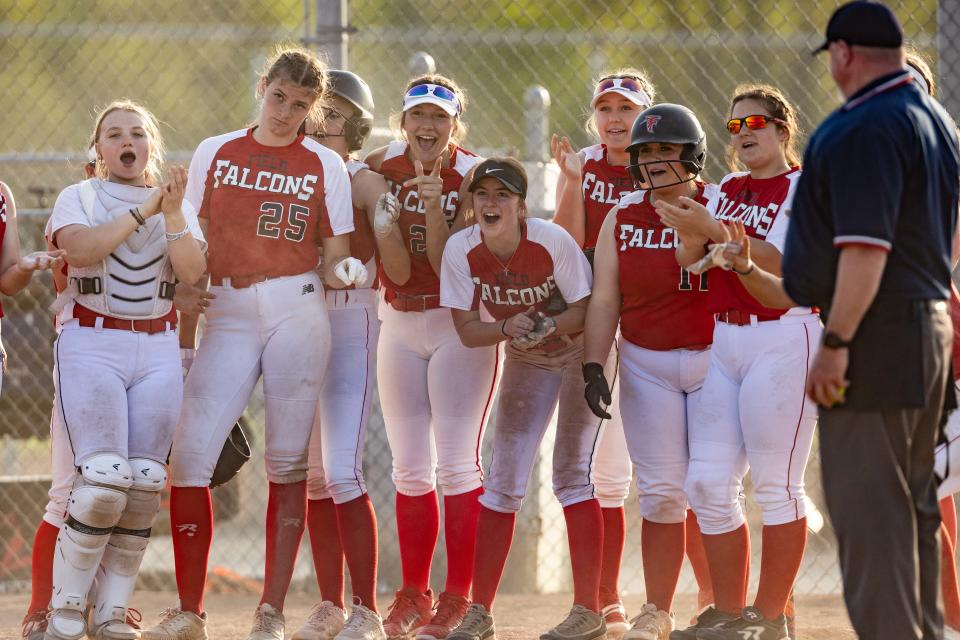 The Field softball team stands at home plate waiting for Maddie Burge to round the bases after hitting a home run during a high school softball game against the Coventry Comets Monday, April 29 in Coventry Township.