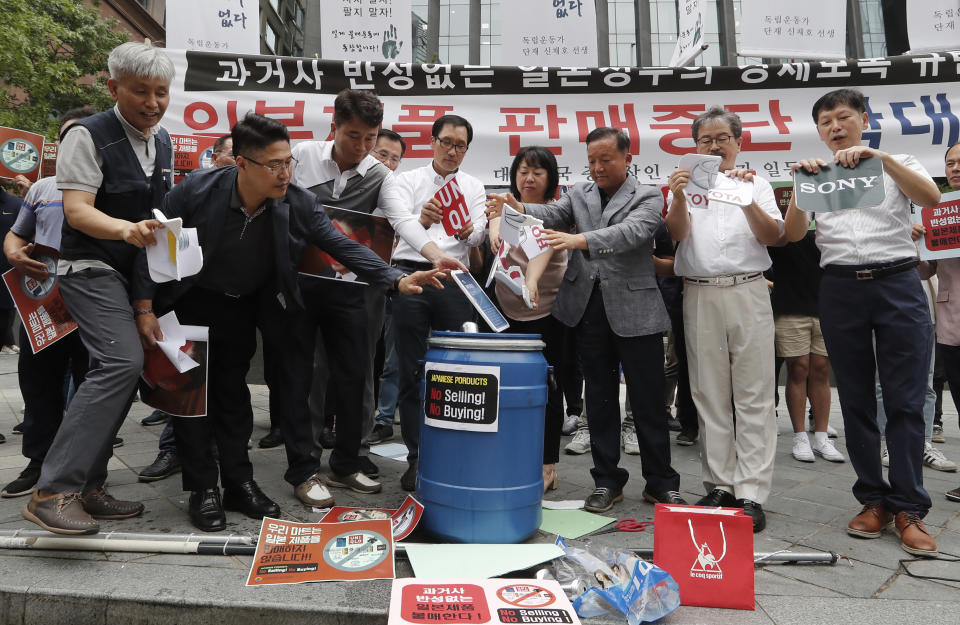 South Korean small and medium-sized business owners throw papers showing logos of major Japanese brands into a trash can during a rally calling for a boycott of Japanese products in front of the Japanese embassy in Seoul, South Korea, Monday, July 15, 2019. South Korea and Japan last Friday, July 12, failed to immediately resolve their dispute over Japanese export restrictions that could hurt South Korean technology companies, as Seoul called for an investigation by the United Nations or another international body. The signs read: "Our supermarket does not sell Japanese products." (AP Photo/Ahn Young-joon)