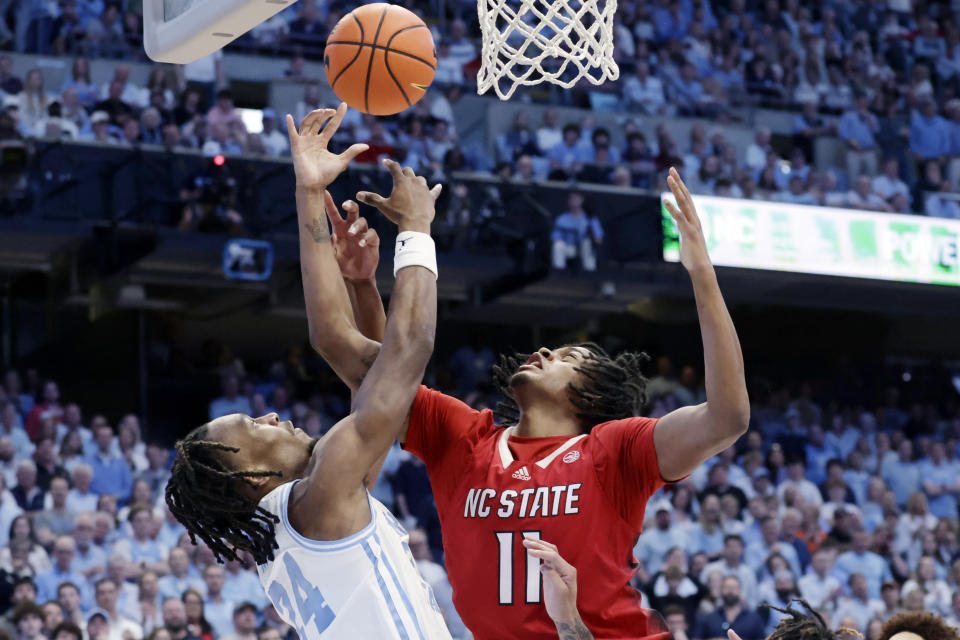 North Carolina State guard Dennis Parker Jr. (11) and North Carolina forward Jae'Lyn Withers (24) vie for a rebound during the second half of an NCAA college basketball game Saturday, March. 2, 2024, in Chapel Hill, N.C. (AP Photo/Chris Seward)
