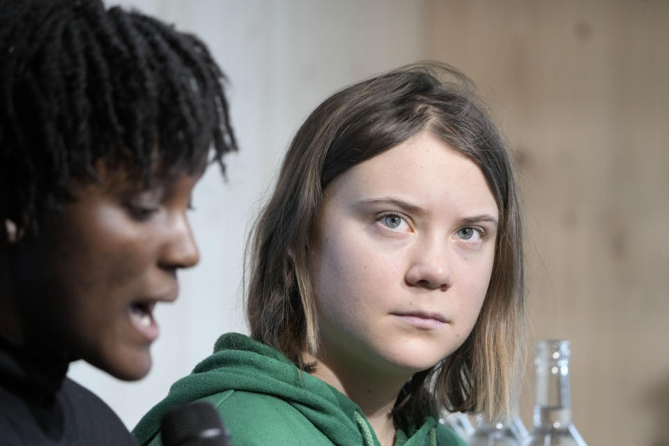 Climate activist Greta Thunberg of Sweden, right, listens to Vanessa Nakate of Uganda, left, at a press conference at the World Economic Forum in Davos, Switzerland Thursday, Jan. 19, 2023. The annual meeting of the World Economic Forum is taking place in Davos from Jan. 16 until Jan. 20, 2023. (AP Photo/Markus Schreiber)