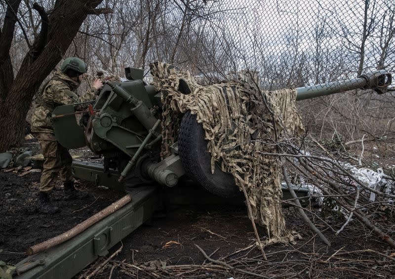 A Ukrainian service member prepares to shoot from a howitzer at a front line near the city of Bakhmut