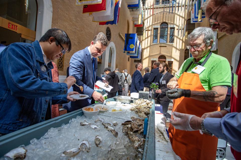 Sen. Ryan Fattman, R-Webster, second from left, takes a sample from the aquaculture table at Agriculture Day, held April 12 in the Statehouse for the first time since 2019.