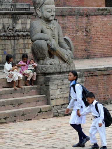 Children are seen at Durbar Square, on their way to school in Bhaktapur, some south-east of Kathmandu. More than half of Nepal's urban under-fives are not registered at birth, meaning they have no official name, identity or nationality, and little access to services provided by the state or protection under the law