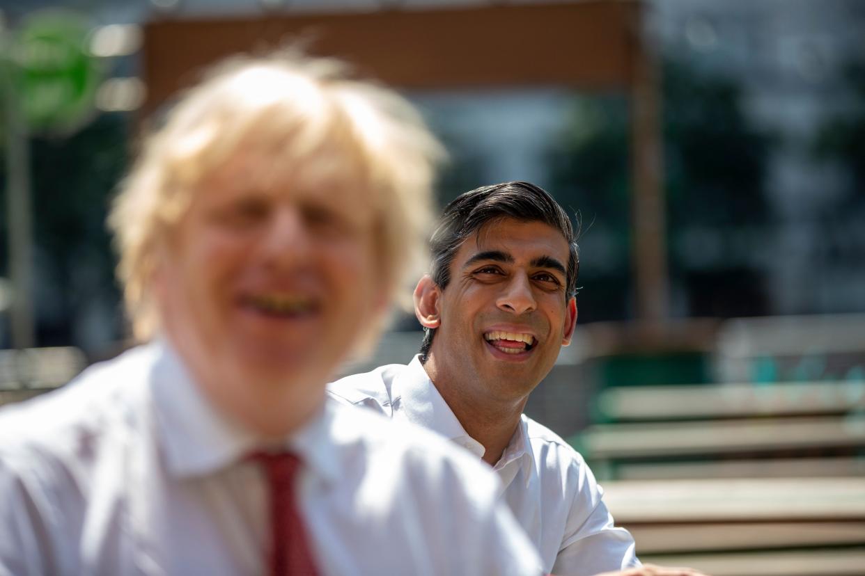 Britain's Prime Minister Boris Johnson (L) reacts as he visits Pizza Pilgrims in West India Quay, London Docklands on June 26, 2020 with Britain's Chancellor of the Exchequer Rishi Sunak (R) as the restaurant prepares to reopen on July 4 as coronavirus lockdown rules are eased. - The British government on Thursday unveiled plans to get the public out of indoor confinement and on to the streets to boost the economy after three months of coronavirus lockdown. Prime Minister Boris Johnson wants pubs and restaurants to be buzzing in the curtailed summer season, despite continued social distancing rules and restrictions. (Photo by Heathcliff O'Malley / POOL / AFP) (Photo by HEATHCLIFF O'MALLEY/POOL/AFP via Getty Images)