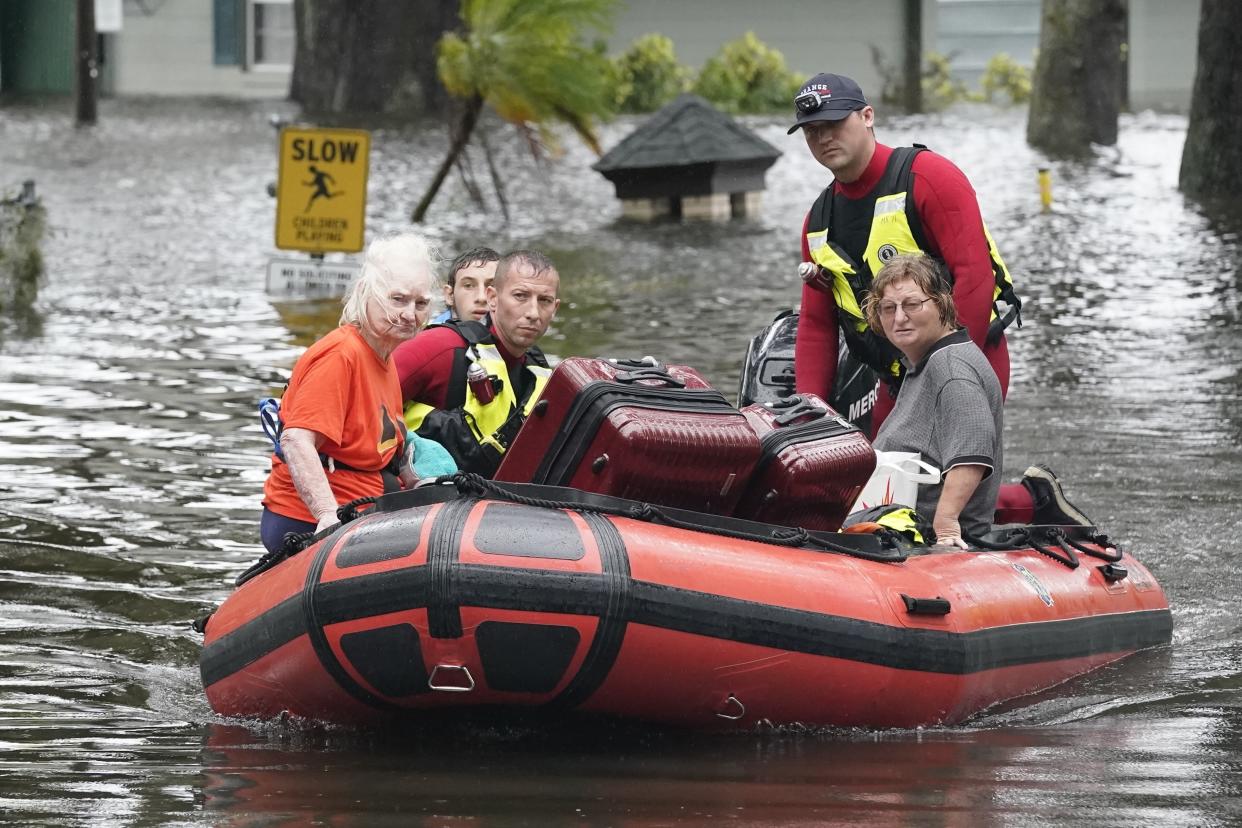 Rescue workers and Orlando residents make their way through floodwaters in a boat.
