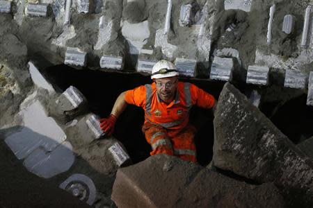 A worker walks over shattered concrete after the tunnelling machine made the breakthrough into the station structure at Canary Wharf, in east London June 11, 2013. REUTERS/Andrew Winning