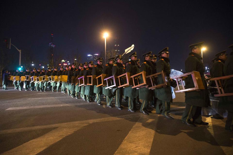 Paramilitary police officers walk on the location where people were killed in a stampede incident during a New Year's celebration on the Bund in Shanghai