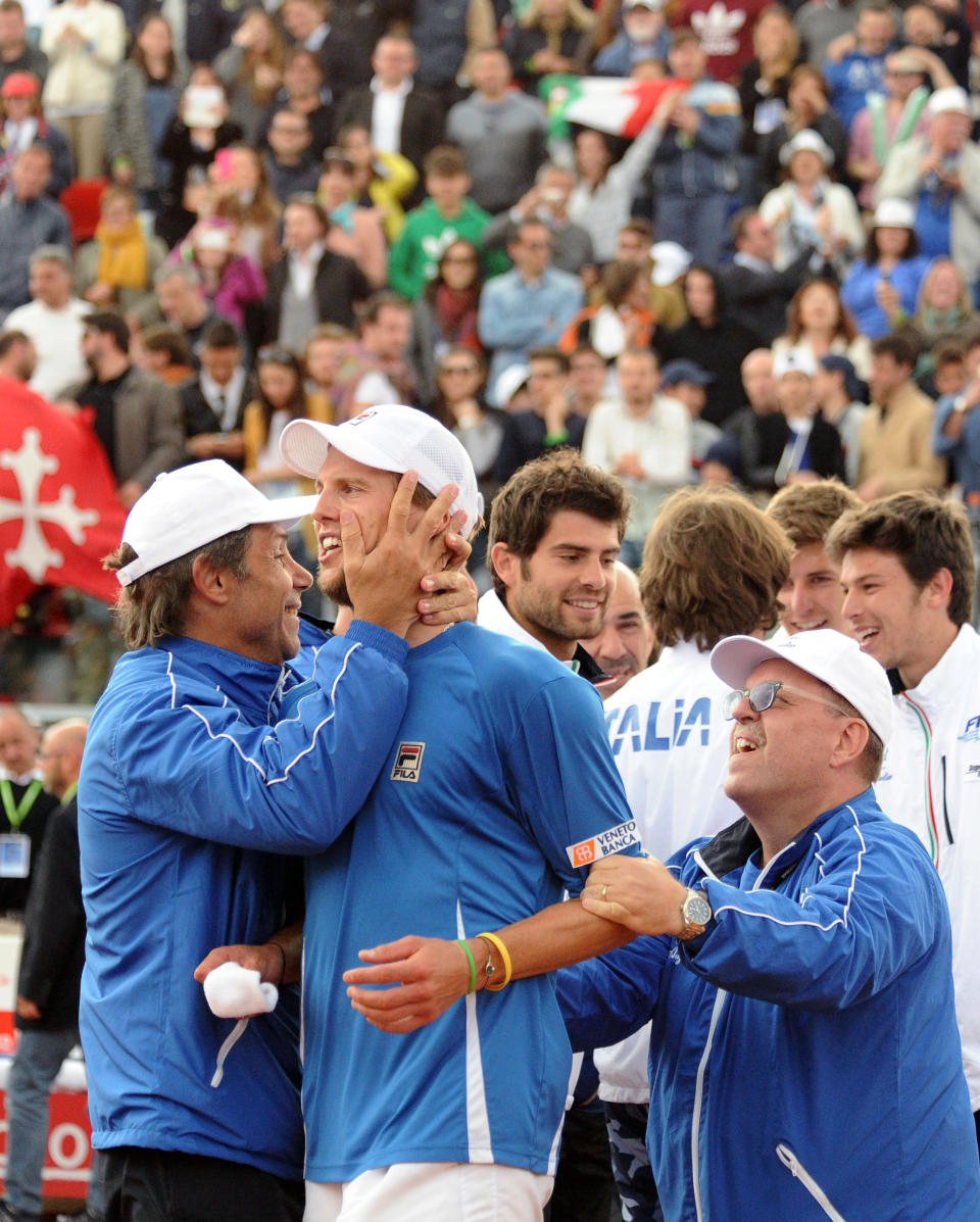 Italy's Andreas Seppi celebrates with team members after beating Britain's James Ward during a Davis Cup World Group quarterfinal tennis match in Naples, Italy, Sunday, April 6, 2014. Italy won both singles matches against Britain in straight sets on Sunday to reach the Davis Cup semifinals for the first time in 16 years. Fabio Fognini pulled off a surprise 6-3, 6-3, 6-4 victory over two-time Grand Slam champion Andy Murray to level the best-of-5 quarterfinal at 2-2 before Andreas Seppi defeated James Ward 6-4, 6-3, 6-4 in the decisive match. (AP Photo/Salvatore Laporta)