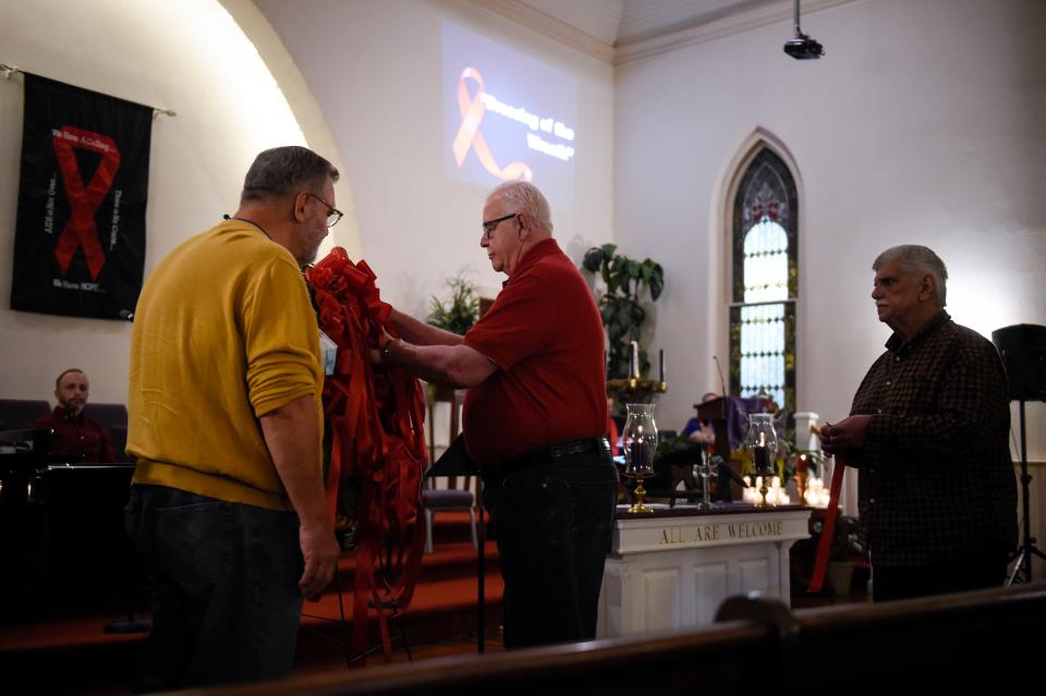 The World AIDS Day remembrance service at the Metropolitan Community Church in Augusta gave people a chance to pin ribbons on a wreath in honor of loved ones.