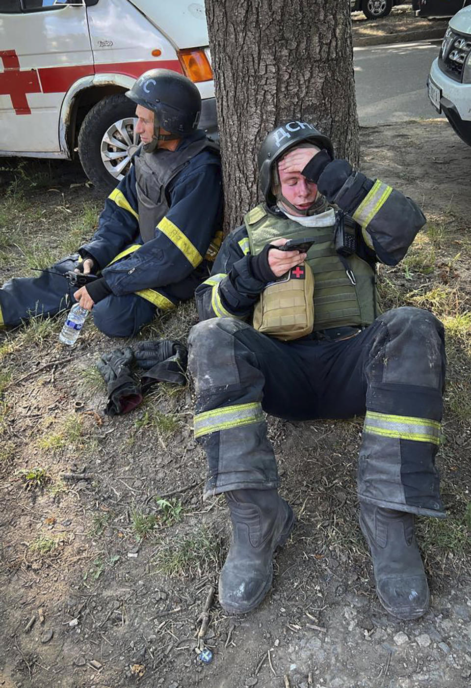In this photo provided by the Ukrainian Emergency Service, emergency workers rest as they clear the rubble after a Russian missile hit the area, in Kryvyi Rih, Ukraine, Wednesday, June 12, 2024. (Ukrainian Emergency Service via AP)