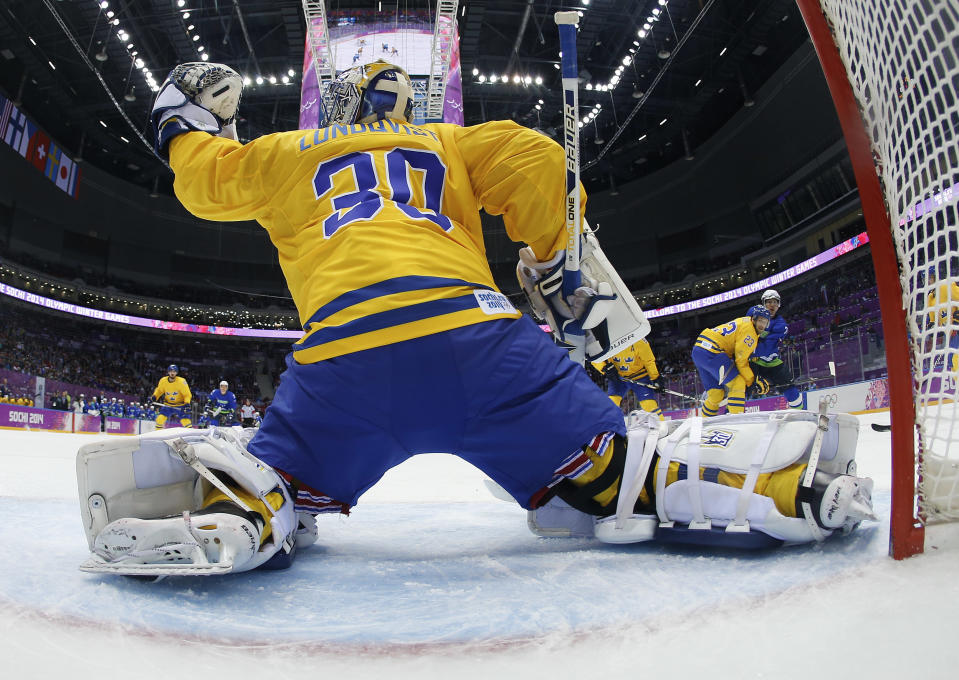 Sweden goaltender Henrik Lundqvist blocks a shot by Slovenia in the first period of a men's ice hockey game at the 2014 Winter Olympics, Wednesday, Feb. 19, 2014, in Sochi, Russia. (AP Photo/Julio Cortez, Pool)