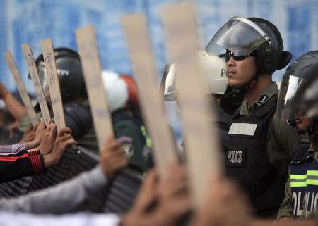 Police officers block a street as protesters demand the release of five opposition members of parliament, near the Phnom Penh Municipal Court in central Phnom Penh July 16, 2014. REUTERS/Samrang Pring