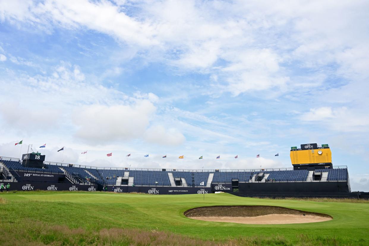 Flags flutter in the breeze above the empty stands around the 18th green during practice for The 149th British Open Golf Championship at Royal St George's, Sandwich in south-east England on July 12, 2021. - RESTRICTED TO EDITORIAL USE (Photo by Paul ELLIS / AFP) / RESTRICTED TO EDITORIAL USE (Photo by PAUL ELLIS/AFP via Getty Images)