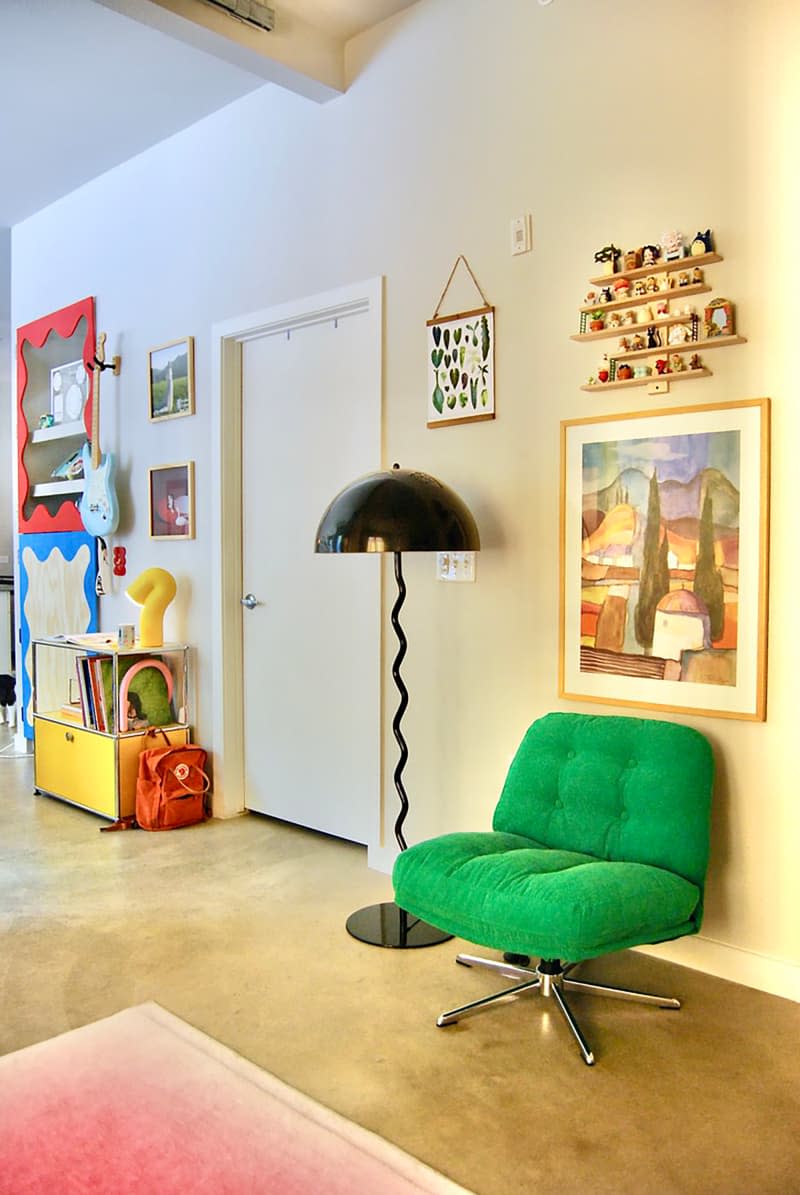 Green accent chair in eclectic apartment.