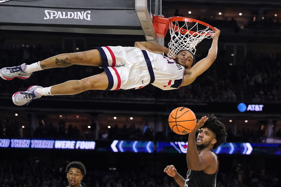 Connecticut guard Andre Jackson Jr. dunks the ball over Miami forward Norchad Omier, right, during the second half of a Final Four college basketball game in the NCAA Tournament on Saturday, April 1, 2023, in Houston. (AP Photo/David J. Phillip)