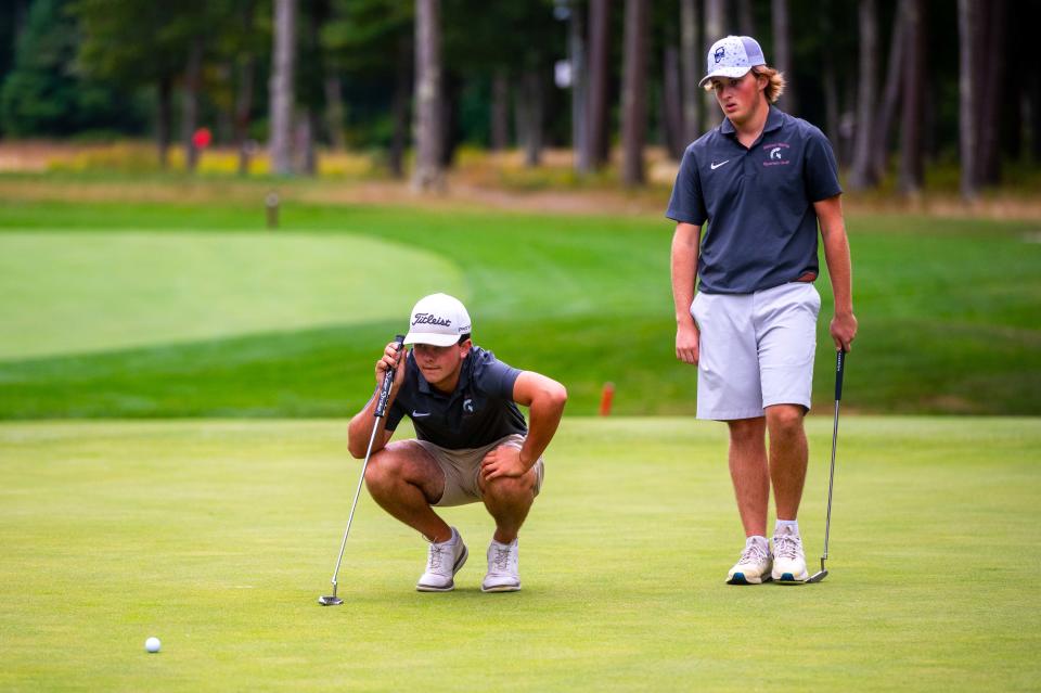 Bishop Stang's Matt Oliveira and Talbot Lown study the green on Hole 6 at the Bay Club.