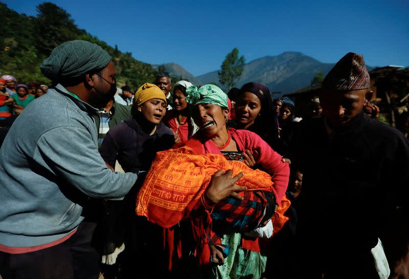 FILE PHOTO: A woman holding a child who died during an earthquake mourns in Jajarkot