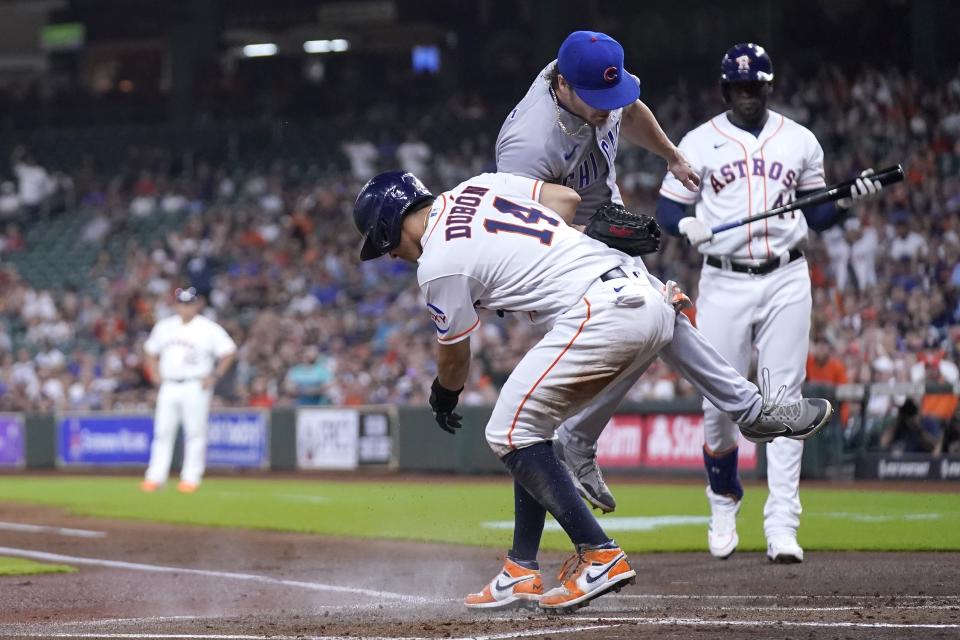 Houston Astros' Mauricio Dubon (14) scores as Chicago Cubs starting pitcher Justin Steele covers home plate after throwing a wild pitch during the first inning of a baseball game Tuesday, May 16, 2023, in Houston. (AP Photo/David J. Phillip)