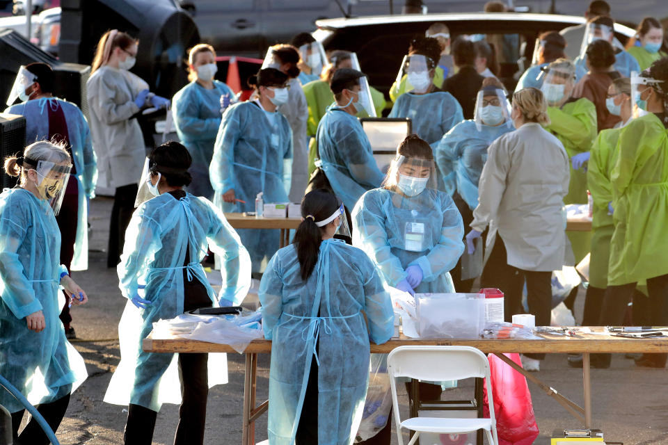 Medical personnel prepare to test hundreds of people lined up in vehicles Saturday, June 27, 2020, in Phoenix's western neighborhood of Maryvalefor free COVID-19 tests organized by Equality Health Foundation, which focuses on care in underserved communities. As coronavirus infections explode in states like Arizona and Florida, people in communities of color are fighting to get tested. Public health experts say wider testing helps people in underserved neighborhoods and is key to controlling a pandemic. (AP Photo/Matt York)