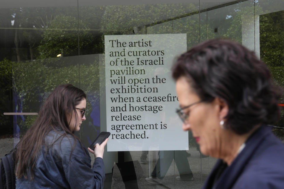 People stand in front of the closed Israeli national pavilion at the Biennale contemporary art fair in Venice, Italy, Tuesday, April 16, 2024. The sign announces that the artist and curators representing Israel at this year's Venice Biennale won't open the Israeli pavilion until there is a cease-fire in Gaza and an agreement to release hostages taken Oct. 7. (AP Photo/Luca Bruno)