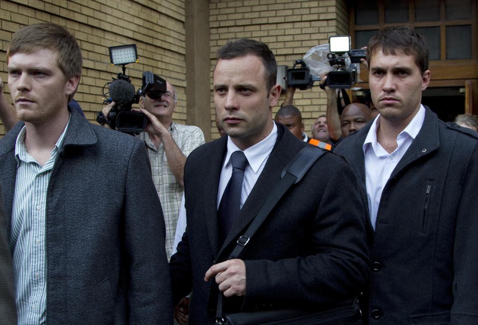 Oscar Pistorius, center, with unidentified men leaves the high court in Pretoria, South Africa, Tuesday, March 11, 2014. Pistorius is charged with murder for the shooting death of his girlfriend, Reeva Steenkamp, on Valentines Day in 2013. (AP Photo/Themba Hadebe)