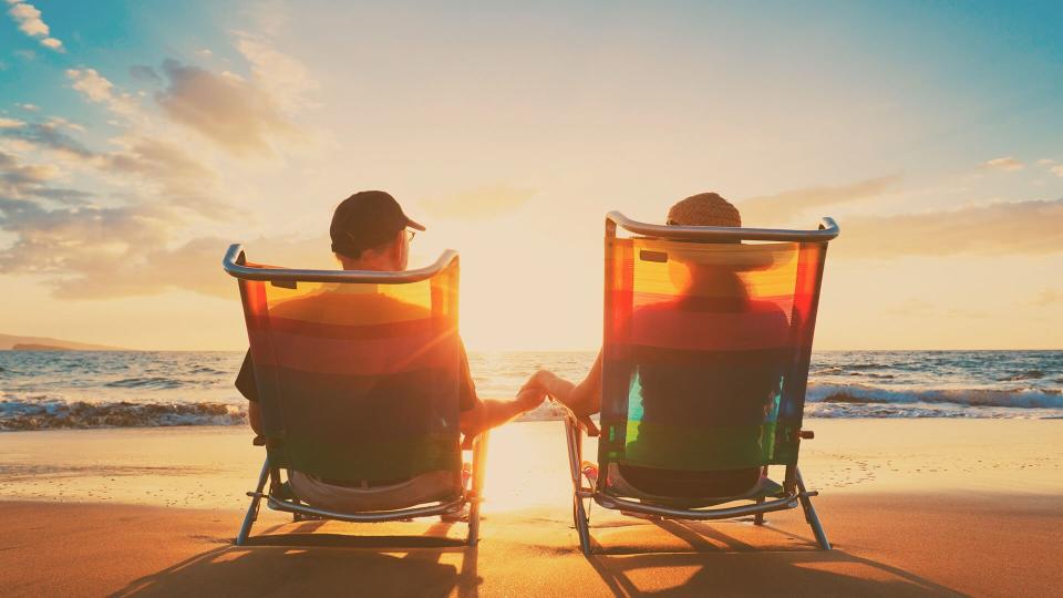 retired couple relaxing in chairs on the beach