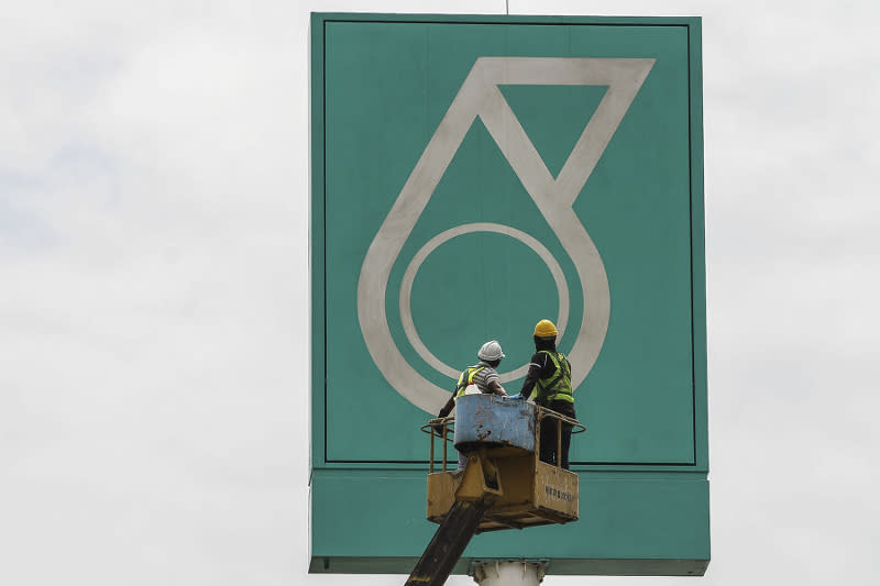 Workers work on a signage bearing a Petronas logo in Kuala Lumpur March 12, 2017. — Picture by Yusof Mat Isa