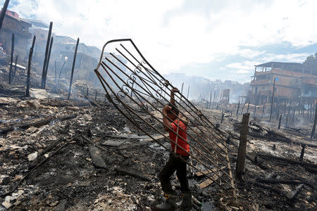 A resident is seen after a fire at Educandos neighbourhood, on a branch of the Rio Negro, a tributary to the Amazon river, in the city of Manaus, Brazil December 18, 2018. REUTERS/Bruno Kelly