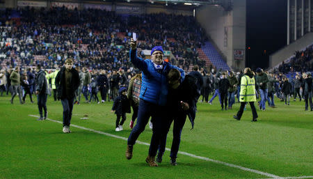 Soccer Football - FA Cup Fifth Round - Wigan Athletic vs Manchester City - DW Stadium, Wigan, Britain - February 19, 2018 Wigan Athletic fans celebrate on the pitch after the match REUTERS/Andrew Yates