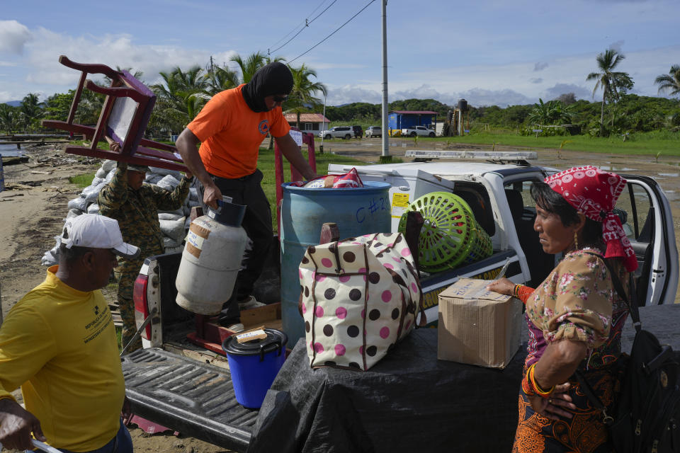 Funcionarios de protección civil, a la izquierda, cargan las pertenencias de una familia en un camión para trasladarse desde la isla de Gardi Sugdub, ubicada frente a la costa caribeña de Panamá, hasta el continente el miércoles 5 de junio de 2024. (AP Foto/Matías Delacroix)