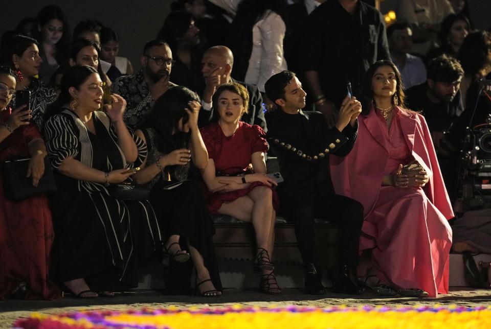 Game of Thrones' star Maisie Williams, center, and Bollywood actress Sonam Kapoor, right, wait for the Dior pre-fall 2023 collection show in Mumbai, India, Thursday, March 30, 2023. (AP Photo/Rafiq Maqbool)