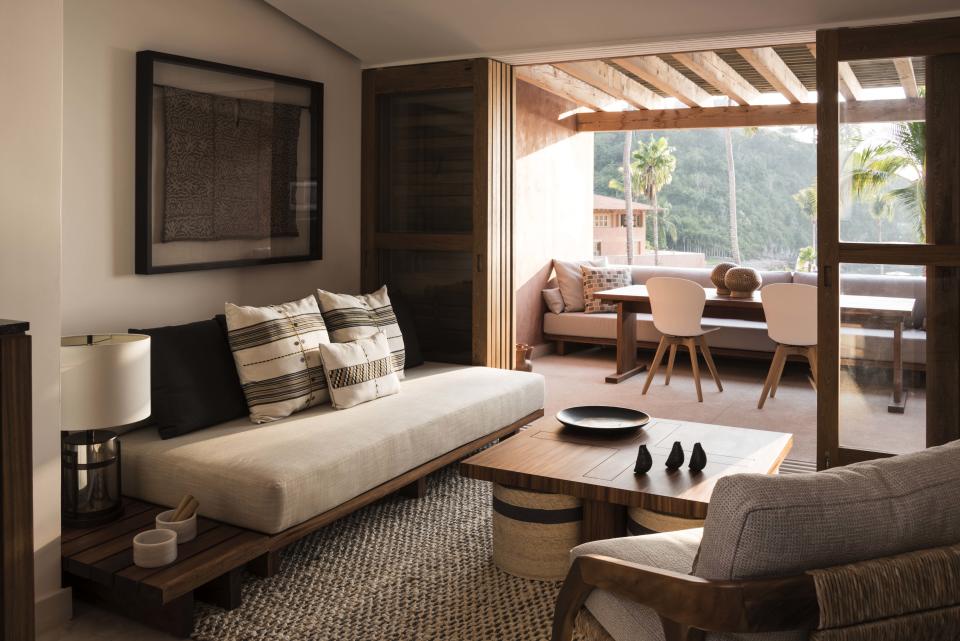 The interiors at El Careyes Club & Residences boast local rosa morada wood, rattan, and green tropical plants.
