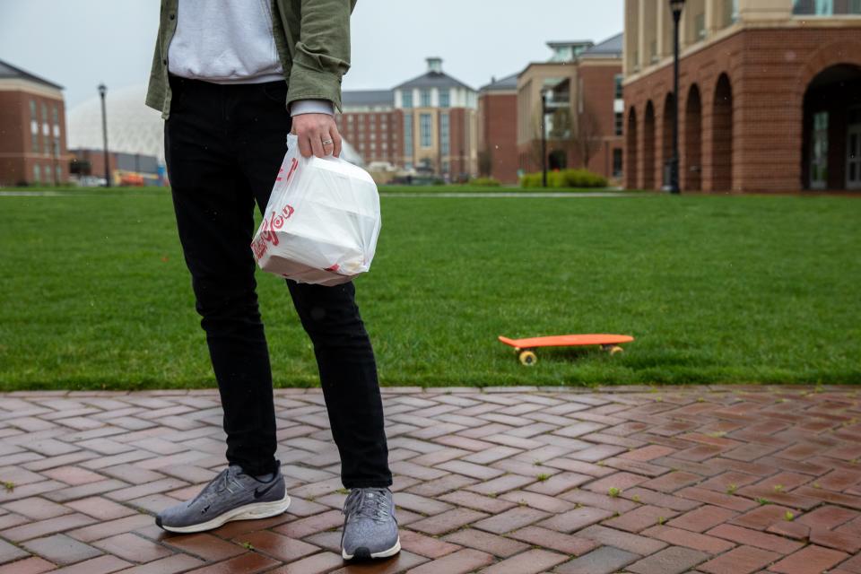 Ruben Erickson, a student at Liberty University in Lynchburg, Virginia, holds a bag of takeout food which he acquired from an on-campus dining hall on March 31, 2020. - Virginia's governor on March, 31, 2020 ordered all higher education institutions to halt any in-person instruction amid the coronavirus pandemic, a move likely directed at Liberty University, which initially declined to stop all on-campus teaching. (Photo by Amanda Andrade-Rhoades / AFP) (Photo by AMANDA ANDRADE-RHOADES/AFP via Getty Images)