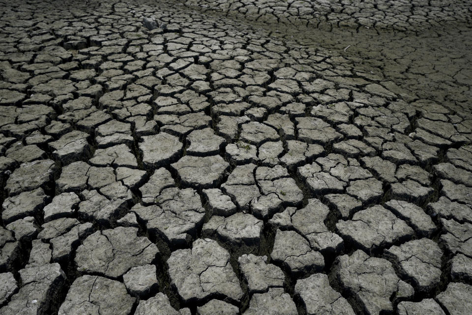 Dry, cracked land is visible in The Boca reservoir that supplies water to the northern city of Monterrey is almost dry as the northern part of Mexico is affected by an intense drought, in Santiago, Mexico, Saturday, July 9, 2022. Local authorities began restricting water supplies in March, as a combination of an intense drought, poor planning and high use has left the three dams that help supply the city dried up, with thousands of homes not receiving any water for weeks. (AP Photo/Fernando Llano)