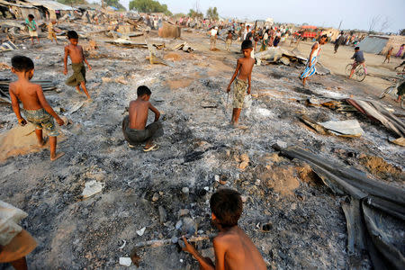 Boys search for useful items among the ashes of burnt houses after fire destroyed shelters at a camp for internally displaced Rohingya Muslims in the western Rakhine State near Sittwe, Myanmar May 3, 2016. REUTERS/Soe Zeya Tun/File Photo