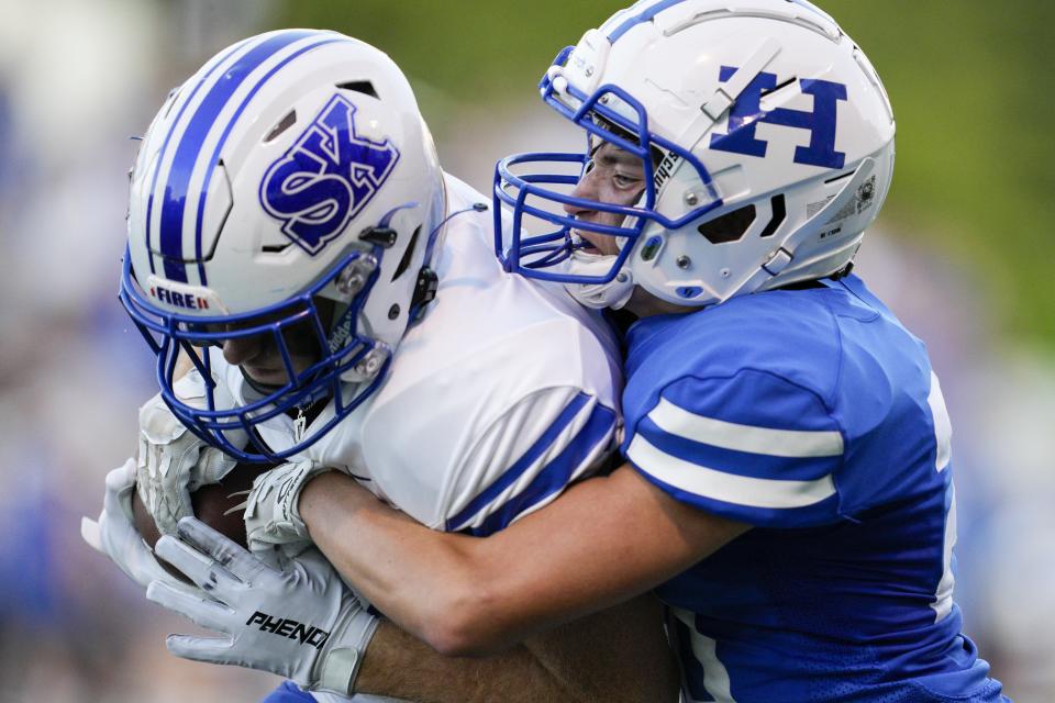 Simon Kenton wide receiver Chase Williams, left, makes a catch while being defended by Highlands' Nathan Welch during a KHSAA high school football game at Highlands High School Friday, Aug. 26, 2022.