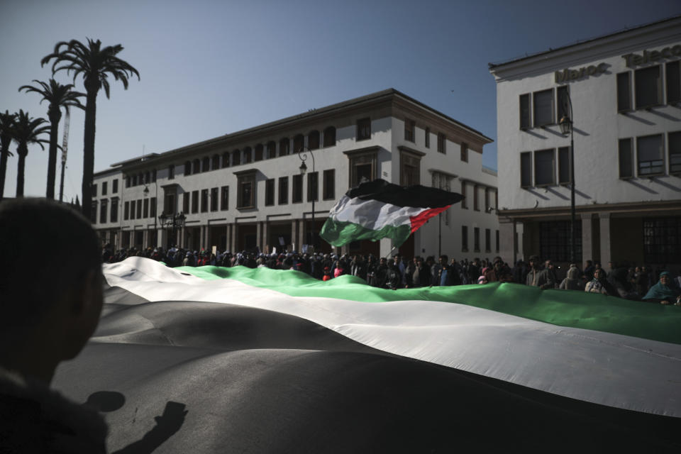 People wave a large Palestinian flag during a demonstration in Rabat, Morocco, Sunday, Feb. 9, 2020. Thousands of Moroccans took part in a march rejecting Trump's Middle East peace plan and in support of Palestinians. (AP Photo/Mosa'ab Elshamy)