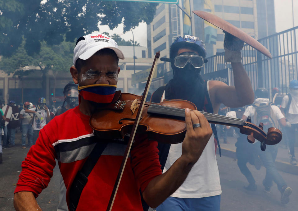 <p>An opposition supporter plays the violin during clashes with riot police, during a rally against President Nicolas Maduro in Caracas, Venezuela, May 8, 2017. (Photo: Carlos Garcia/Reuters) </p>