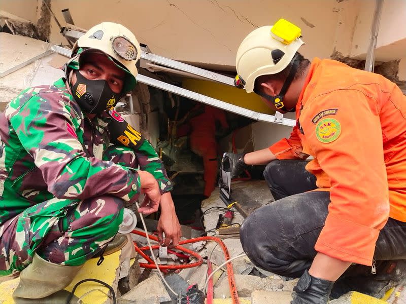 Members of a search and rescue agency team work after an earthquake, in Mamuju