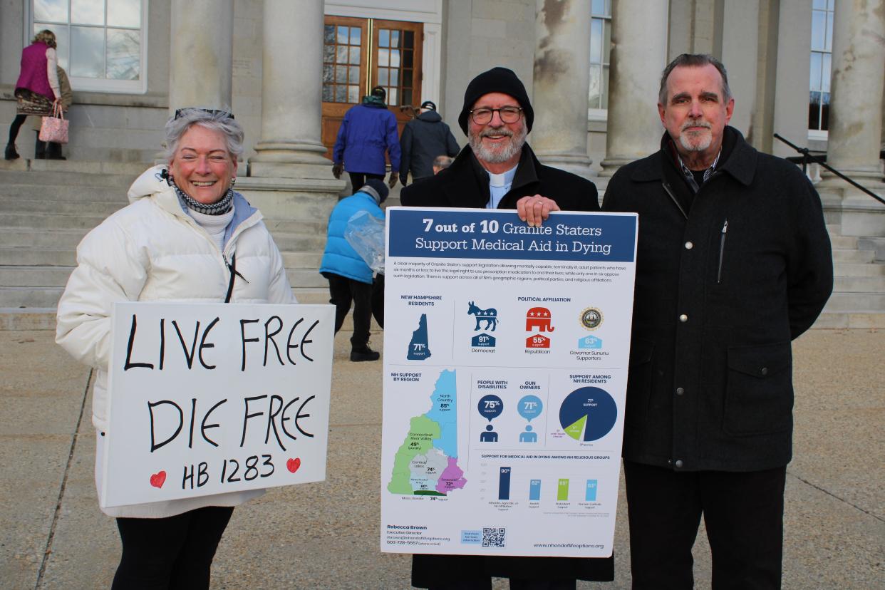 Aylene Wozmak, the Rev. Peter Friedrichs and former state representative Ed Butler support the End of Life Options Act in front of the New Hampshire Statehouse in Concord on Thursday, March 21, 2024.