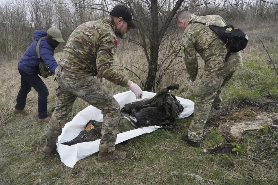 FILE - Ukrainian servicemen pack the dead body of a Russian soldier, killed in a recent battle in the Kharkiv region, Ukraine, Saturday, April 8, 2023. Nearly 50,000 Russian soldiers have died in the war in Ukraine, according to the first independent statistical analysis of Russia’s war dead. (AP Photo/Andrii Marienko, File)