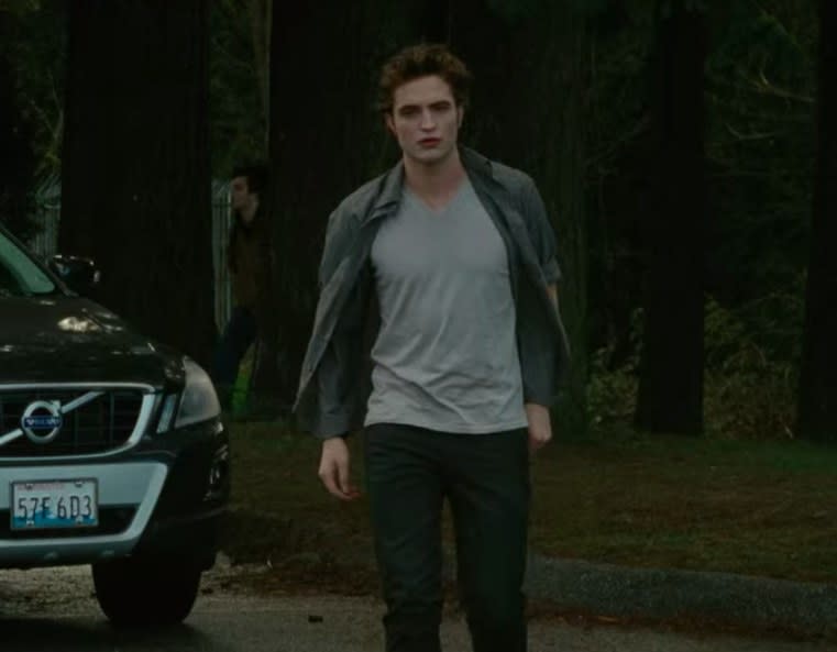 Edward wearing jeans, a t shirt, and an unbuttoned shirt on top of it
