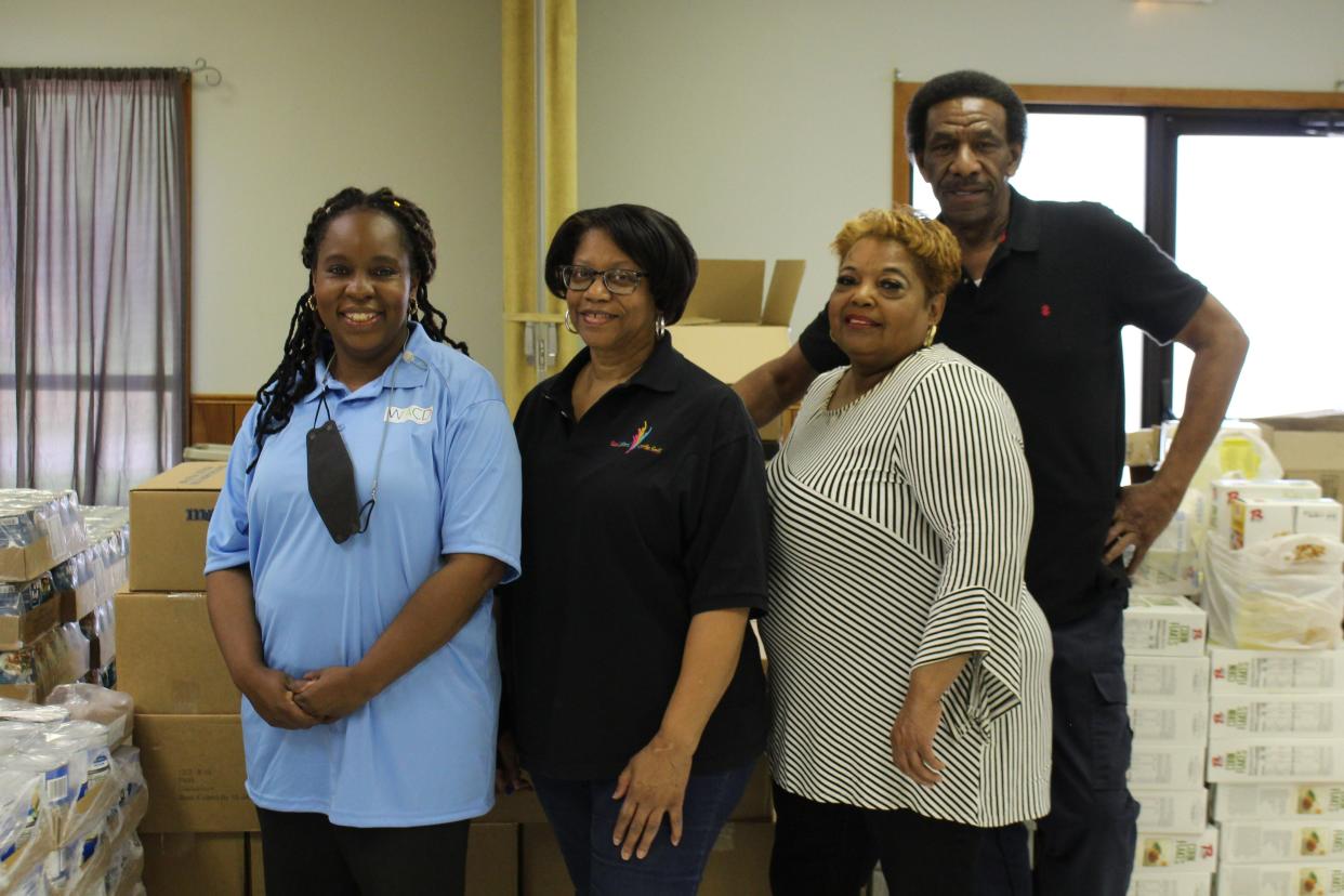 LaToya Shepherd, Mary Williams, Tina Gordon and Sterling Stratford, with the Mission United Methodist Church Food Pantry, stand in front of food pallets inside the church, April 26, 2022.