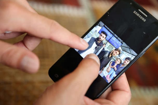 PHOTO: Najib Mohammadi points out family members in a photo taken on the day he and his wife Susan Mohammadi left Afghanistan for the U.S., on his phone, at his home in Sacramento, Calif, Aug. 1, 2022. (Brittany Hosea-Small/Reuters)