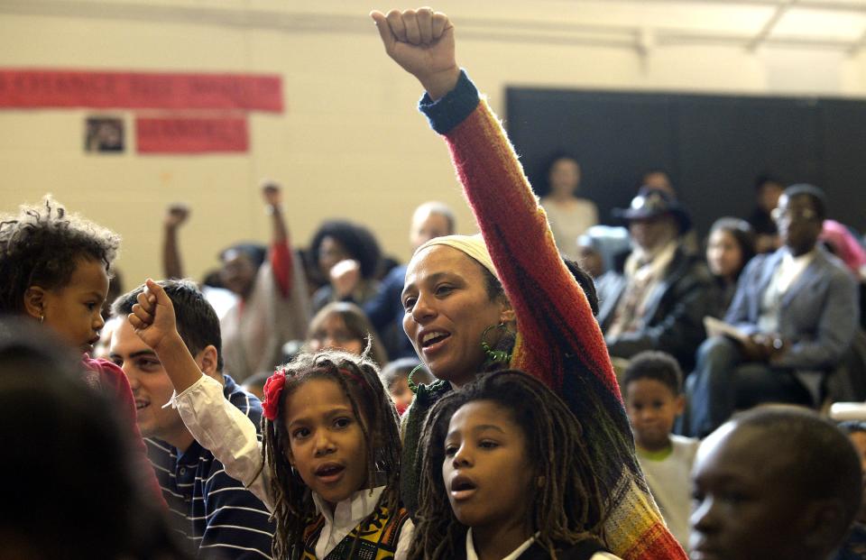 Mary Ann Scott (C), with her son Tesfa Scott (R) and daughter Selam (L), attends a ceremony at Nelson Mandela Park Public School in Toronto, December 6, 2013. Students, staff and school board officials gathered at the school to pay tribute to Mandela with songs and tributes. Mandela visited the school, which was previously known as Park Public, on November 17, 2001, when it was renamed in his honour. South African anti-apartheid hero Mandela died at the age of 95 on Thursday. REUTERS/Aaron Harris (CANADA - Tags: EDUCATION POLITICS OBITUARY)