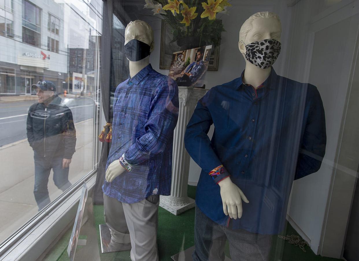 <span class="caption">A man heads past a clothing store where mannequins sport face masks in Halifax. Retail workers, long-term care workers and teachers say the media has failed to reflect their pandemic experiences.</span> <span class="attribution"><span class="source">THE CANADIAN PRESS/Andrew Vaughan </span></span>